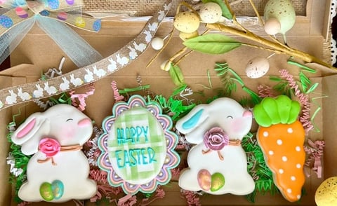 Easter-themed decorative items including white bunny ornaments, Happy Easter sign, and carrot decoration in a display box